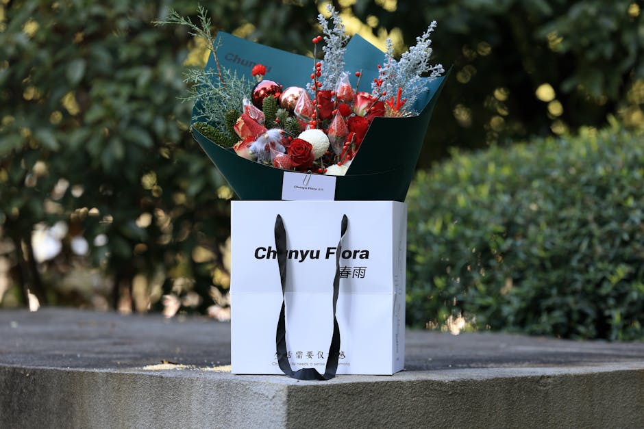 Luxurious bouquet with red roses and decorations in a white gift bag outdoors.